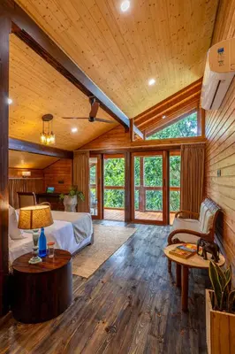 a bedroom with a bed in a room with wooden walls at amã Stays and Trails The Malabar Villa Hibiscus, Kozhikode in Puthuppādi