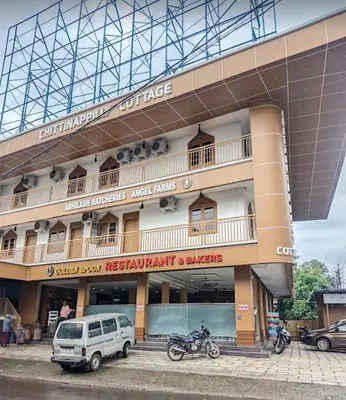 a building with a van parked in front of it at Chittinappilly Cottage in Angamali