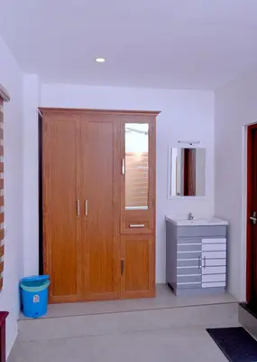 a bathroom with a wooden cabinet and a sink at Chittinappilly Cottage in Angamali