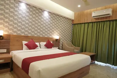 a hotel room with a large bed and a chair at HOTEL VKJ INN Aluva in Alwaye