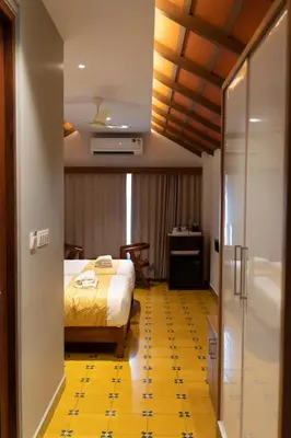 a hotel room with a bed and a bathroom at Palcastle Regency in Palakkad