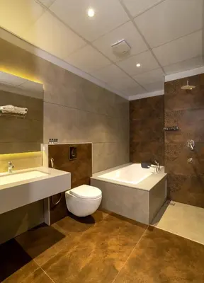 a bathroom with a tub and a toilet and a sink at Palcastle Regency in Palakkad
