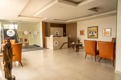 a large room with orange chairs and a kitchen at HOTEL ACHYUT in Tiruppūr