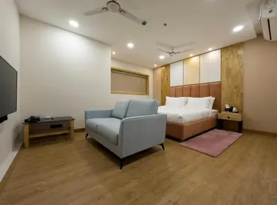a bedroom with a bed and a couch and a chair at The Habitat Suites-Walkable distance to Guruvayoor temple in Guruvāyūr