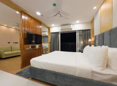 a hotel room with a bed and a flat screen tv at The Habitat Suites-Walkable distance to Guruvayoor temple in Guruvāyūr