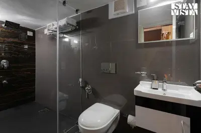a bathroom with a shower and a toilet and a sink at StayVista at Nature Nook with Pvt Pool & Terrace Access in Trichūr