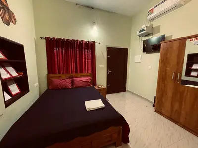 a bedroom with a bed and a red curtain at MO’s Agro in Pāppinisseri