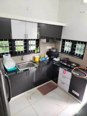 a kitchen with black and white cabinets and a sink at Olive Homestay 1bhk Diamond Ernakulam in Alwaye