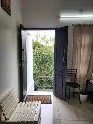 a door to a room with a bench and a table at Olive Homestay 1bhk Diamond Ernakulam in Alwaye