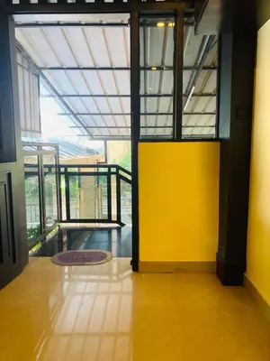 an empty room with a yellow wall and windows at Joys Stay in Trichūr
