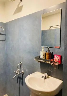 a bathroom with a sink and a mirror at Joys Stay in Trichūr
