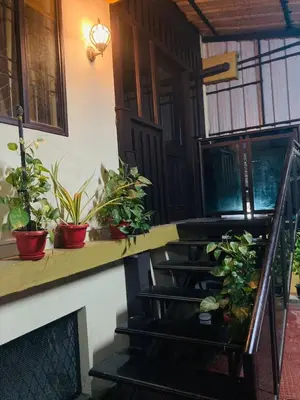 a stairway with potted plants on a wall at Joys Stay in Trichūr