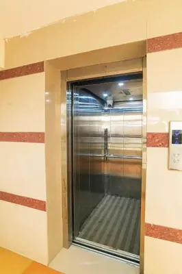 a corner of a room with a glass window at VVP serviceapartments cochin Airport in Nedumbassery