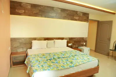 a bedroom with a large bed with a wooden headboard at Kaira Regency in Olakara