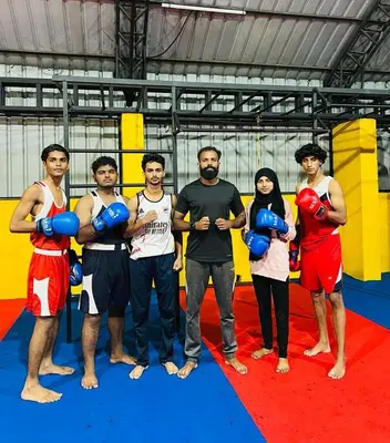 a group of people standing in a boxing ring at Kaira Regency in Olakara