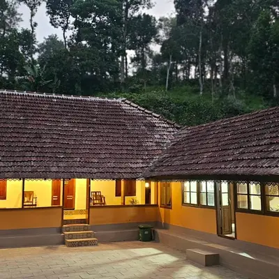a building with a large roof with a patio at Moksha The blissful escape in Kaniyāmbetta