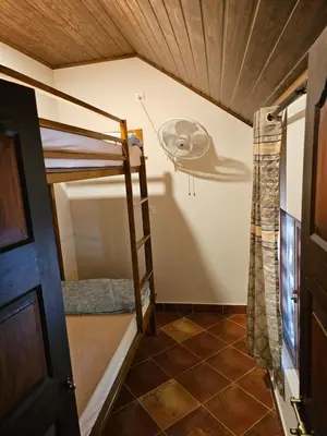 a room with a bunk bed and a ceiling fan at Moksha The blissful escape in Kaniyāmbetta