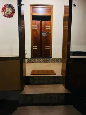 a hallway with a wooden door in a building at Moksha The blissful escape in Kaniyāmbetta