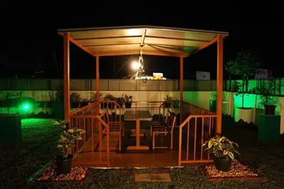 a gazebo with a table in it at night at UNIVERSAL RESIDENCY in Perumbavoor
