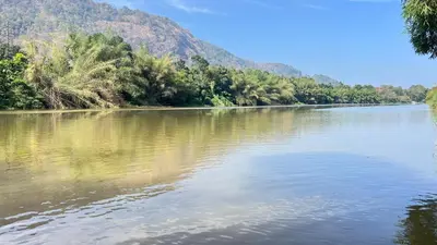 a body of water with trees and mountains in the background at Coconut Valley in Neriyamangalam
