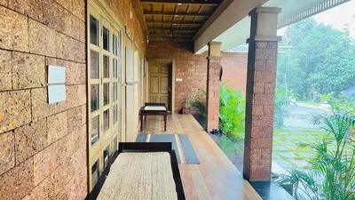 a porch of a brick building with a bench at Coconut Valley in Neriyamangalam