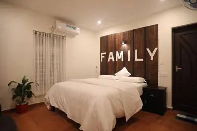 a bedroom with a large bed with a family sign on the wall at Village of Blossom in Ernakulam