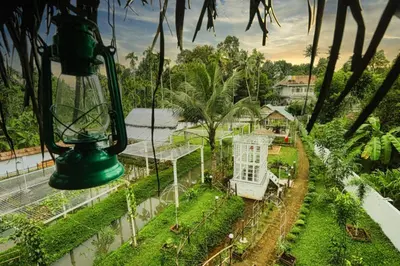 a green light in a garden with a house at Village of Blossom in Ernakulam