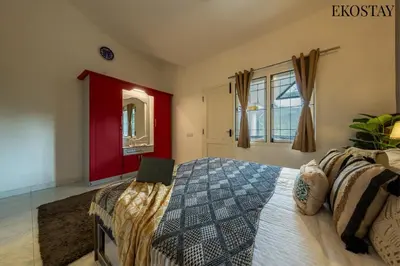 a bedroom with a bed with a laptop on it at EKOSTAY - Moonlight Villa in Kodaikānāl