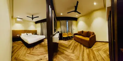 a hotel room with a bed and a couch at S K Legacy Hotel in Mysore