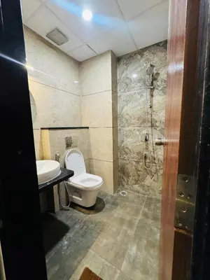 a bathroom with a toilet and a sink and a shower at S K Legacy Hotel in Mysore