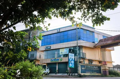 a building with blue glass windows on a street at AN REGENCY in Edappāl