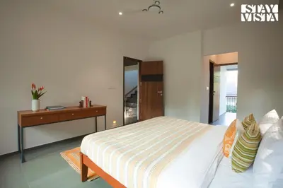 a bedroom with a bed and a dresser with a mirror at StayVista at The Big Chill with Breakfast Included in Wayanad