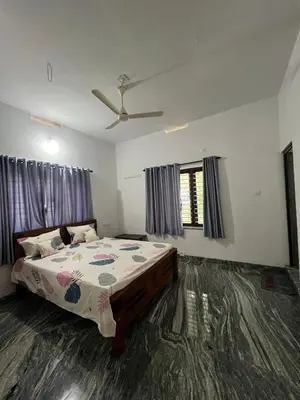 a bedroom with a bed and a ceiling fan at Mount River Homestay in Palakkad