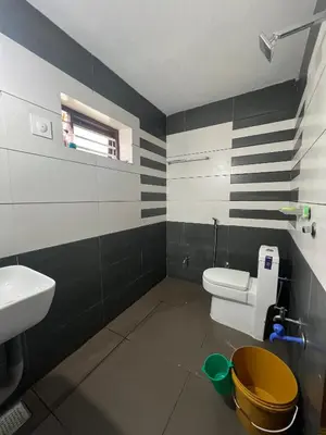 a bathroom with a white toilet and a sink at Mount River Homestay in Palakkad