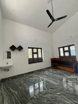 a living room with a ceiling fan and a couch at Mount River Homestay in Palakkad