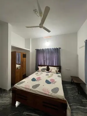 a bedroom with a bed and a ceiling fan at Mount River Homestay in Palakkad