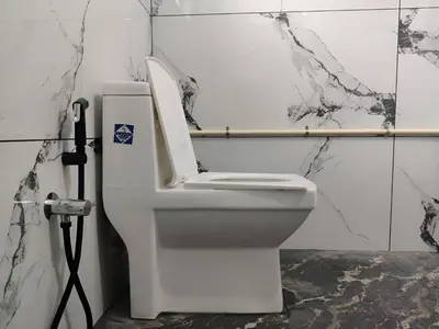 a white toilet in a bathroom with marble walls at Spacious 2BHK Near Airport in Cochin