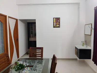 a dining room with a glass table and a sink at Spacious 2BHK Near Airport in Cochin