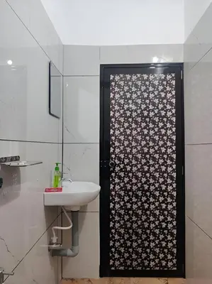 a bathroom with a shower with a sink and a door at Spacious 2BHK Near Airport in Cochin