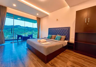 a bedroom with a large bed and a table at Kodai Outdoor Valley in Kodaikānāl