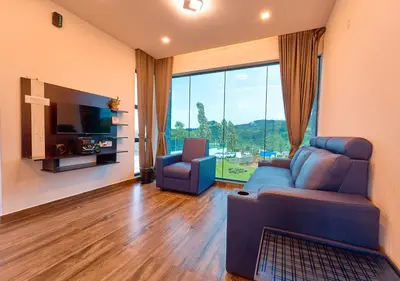 a living room with a couch and a tv at Kodai Outdoor Valley in Kodaikānāl