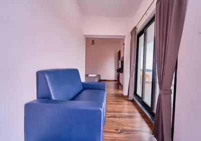 a blue chair in a room with a window at Kodai Outdoor Valley in Kodaikānāl