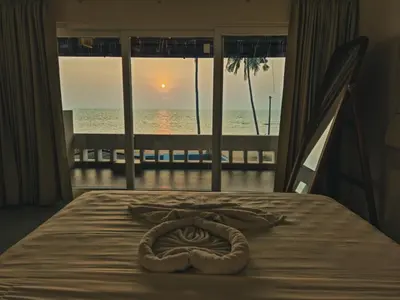 a rope on a bed with a view of the ocean at Kappad Beach House by Kisah Stays in Kappad