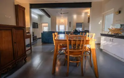 a kitchen and dining room with a wooden table and chairs at Kappad Beach House by Kisah Stays in Kappad