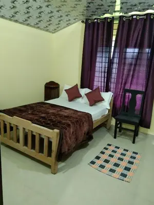 a bedroom with a bed with purple curtains and a chair at Samz estate stay 2BHK in Madikeri