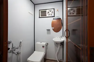 a small bathroom with a toilet and a sink at Golden Triangle River side Cabin in Mysore