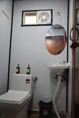 a bathroom with a toilet and a sink at Golden Triangle River side Cabin in Mysore