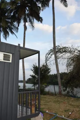 a building with a view of a body of water at Golden Triangle River side Cabin in Mysore