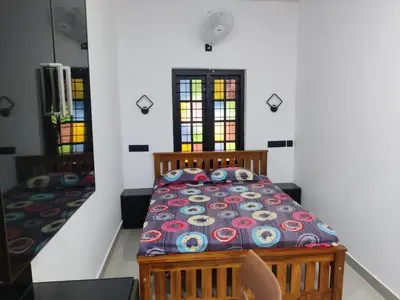 a bedroom with a bed and stained glass windows at Woodside Haven in Chekadi