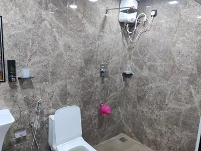 a bathroom with a shower with a white toilet at Woodside Haven in Chekadi